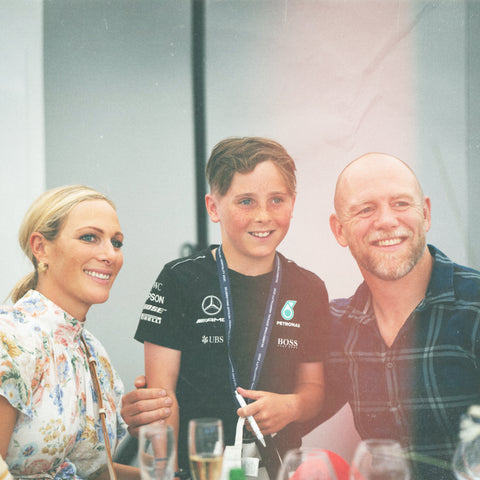 Mike Tindall and Zara Philips pose for a photo with a young fan at The Green Room